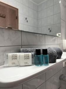a bathroom with three bottles of one for you on a sink at The Steakhouse - Guest Rooms in Sankt Johann im Pongau