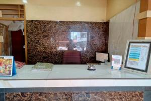 a counter in a room with a stone wall at OYO 93479 Hotel Jaguar Sentani in Jayapura