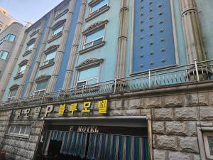 a large blue building with a sign on it at Blue Motel in Busan