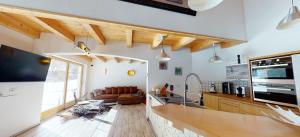 uma cozinha e sala de estar com tectos em madeira e um sofá em Zillertal Residenz em Ginzling