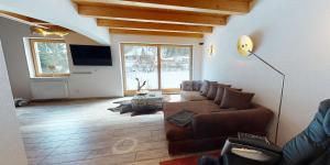 uma sala de estar com um sofá e uma televisão em Zillertal Residenz em Ginzling