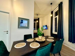 une salle à manger avec une table et des chaises vertes dans l'établissement Luxury Suites Mons, à Mons