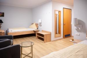 Habitación pequeña con cama, mesa y espejo. en Hotel & Café Ritter von Böhl en Deidesheim