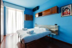 a blue room with a bed with towels on it at Roomy Apartment with Balcony! in Milan