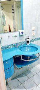 ein Badezimmer mit einem blauen Waschbecken und einem Spiegel in der Unterkunft Квартира на Иксанова in Oral