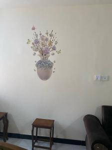 a vase with flowers on a white wall at Murree Oaks Tulip Block in Murree
