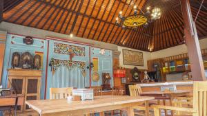 a dining room with wooden tables and chairs at Taman Prabhawa in Sukawati