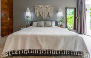 a bedroom with a large bed with a white bedspread at Luz de Luna Tulum Suite III in Tulum