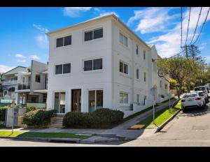 un edificio blanco al lado de una calle en Little Manly 3 bedroom Oasis, en Sídney