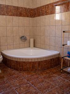 a bath tub in a bathroom with brown tiles at Studios Anna Maria in Kapetanianá