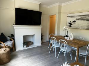 sala de estar con chimenea, mesa y sillas en Little Manly 3 bedroom Oasis en Sídney