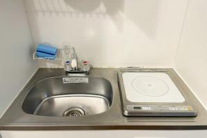 a sink in a small kitchen with a scale at Lavie Heights in Osaka