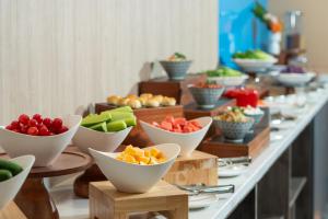 una línea de buffet con cuencos de frutas y hortalizas en Holiday Inn Express Weifang City Center, an IHG Hotel en Weifang