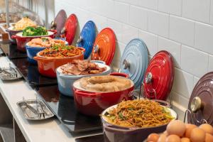 a buffet with bowls of food and plates of food at Holiday Inn Express Weifang City Center, an IHG Hotel in Weifang