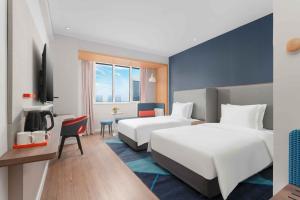 イ坊市にあるHoliday Inn Express Weifang City Center, an IHG Hotelのベッド2台とデスクが備わるホテルルームです。