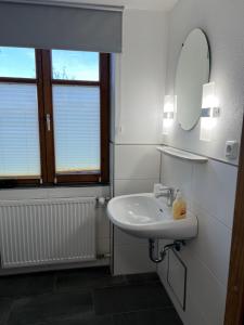 a white bathroom with a sink and a mirror at Gasthof Löwen in Pfronten