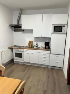 a kitchen with white appliances and a wooden floor at Gasthof Löwen in Pfronten