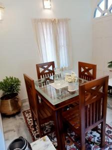 a dining room with a glass table and chairs at Padamadan homestay in Cochin