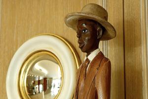 a statue of a man wearing a hat in front of a mirror at Hotel Montecarlo in Bibione