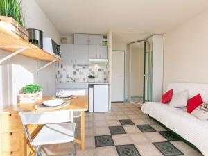 uma cozinha e sala de estar com uma mesa e um sofá em Studio Saint-Lary-Soulan, 1 pièce, 4 personnes - FR-1-296-488 em Saint-Lary-Soulan