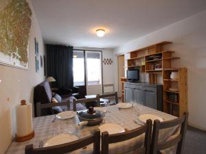 a living room with a dining room table and a kitchen at Appartement Chamrousse, 3 pièces, 6 personnes - FR-1-340-275 in Chamrousse