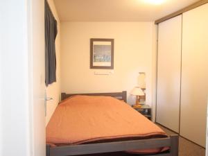 une chambre avec un lit avec une couverture orange dans l'établissement Appartement 2 pièces + cabine, 6 places, 36m², proche pistes, balcon, exposé Sud-Ouest - FR-1-340-275, à Chamrousse