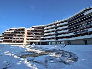 un grande edificio con neve di fronte di Appartement Chamrousse, 3 pièces, 6 personnes - FR-1-340-275 a Chamrousse