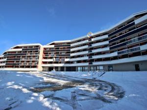 un grand bâtiment avec de la neige devant lui dans l'établissement Appartement 2 pièces + cabine, 6 places, 36m², proche pistes, balcon, exposé Sud-Ouest - FR-1-340-275, à Chamrousse