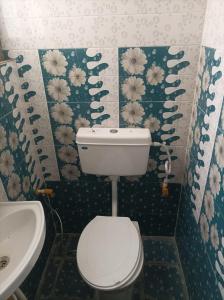 a small bathroom with a toilet and a sink at Hotel Dharam Mukti Utsav Bhawan (DMUB) in Raxaul