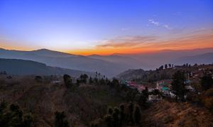 a view of a mountain with a sunset in the background at Treebo The Northern Retreat Resort With Mountain View in Shimla