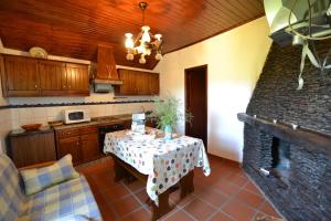 a kitchen with a table and a kitchen with a stove at Branda da Aveleira in Branda da Aveleira