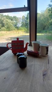 Una mesa con dos tazas y un carro rojo. en Busmans Holiday Anyone, en Pontypool