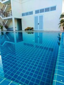 - une piscine dans une maison avec une piscine bleue dans l'établissement Mayflower Grande Hotel Phitsanulok, à Phitsanulok