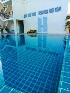 a swimming pool in a house with a blue pool at Mayflower Grande Hotel Phitsanulok in Phitsanulok