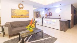 un soggiorno con divano e tavolo con fiori di RedDoorz at Comfy Inn Ermita Manila a Manila