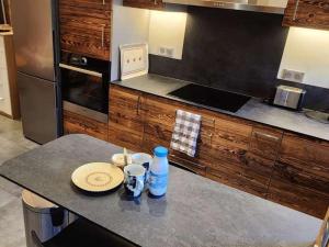 a kitchen with a counter with a plate and a bottle of water at Appartement rénové Les Gets, 4 pers., balcon, parking, navette gratuite - FR-1-623-354 in Saint Pierre en Faucigny
