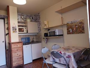 a kitchen with a table and chairs in a room at Studio Bourg-Saint-Maurice, 1 pièce, 3 personnes - FR-1-411-920 in Bourg-Saint-Maurice