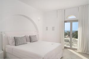 a white bedroom with a bed and a large window at White Dunes Luxury Boutique Hotel in Santa Maria +37 photos