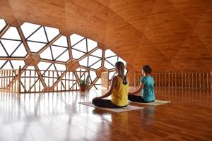Dos mujeres sentadas en el suelo en una sala de yoga en ViaVia Harganat Lodge, 