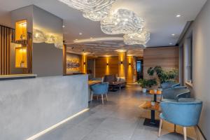 un vestíbulo con sillas, mesas y lámparas de araña en Hotel Ariston Garden & Spa, en Monclassico