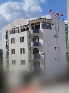 un edificio blanco con un cartel encima en Park Lane Addis Hotel en Addis Abeba