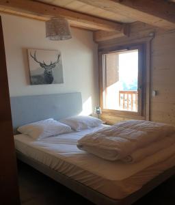 a bedroom with a bed with a deer picture on the wall at LOdyssée 203 in La Toussuire