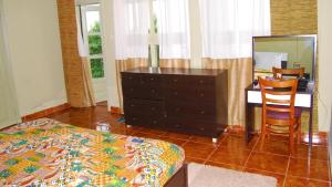 1 dormitorio con tocador y escritorio con espejo en Nyungwe Hill View Hotel, en Rwumba