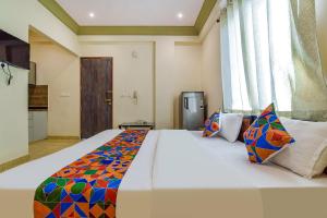 a bedroom with a large bed with a colorful blanket at FabHotel Bungalow 18 in Jaipur