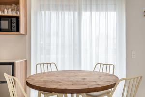 - une table et des chaises en bois dans une cuisine avec une fenêtre dans l'établissement Kallithea Apartments by Olala Homes, à Athènes