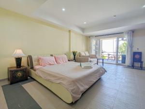 a bedroom with a large bed with pink pillows at Seaview Apartment in Siam Royal View in Ban Khlong Son