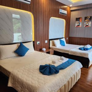 1 dormitorio con 2 camas y almohadas azules en Khu du lịch Hang Rái - Ninh Thuận en Thôn Thái An