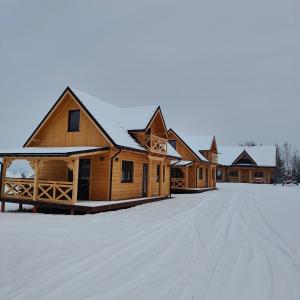 a row of wooden buildings in the snow at beskid.house1 in Spytkowice
