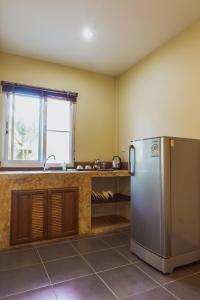 a kitchen with a stainless steel refrigerator and a sink at Sweet Mango Khaolak in Khao Lak