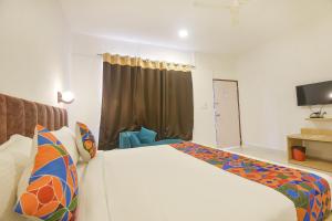 Habitación de hotel con cama y TV en FabHotel Morjim Bliss, en Morjim